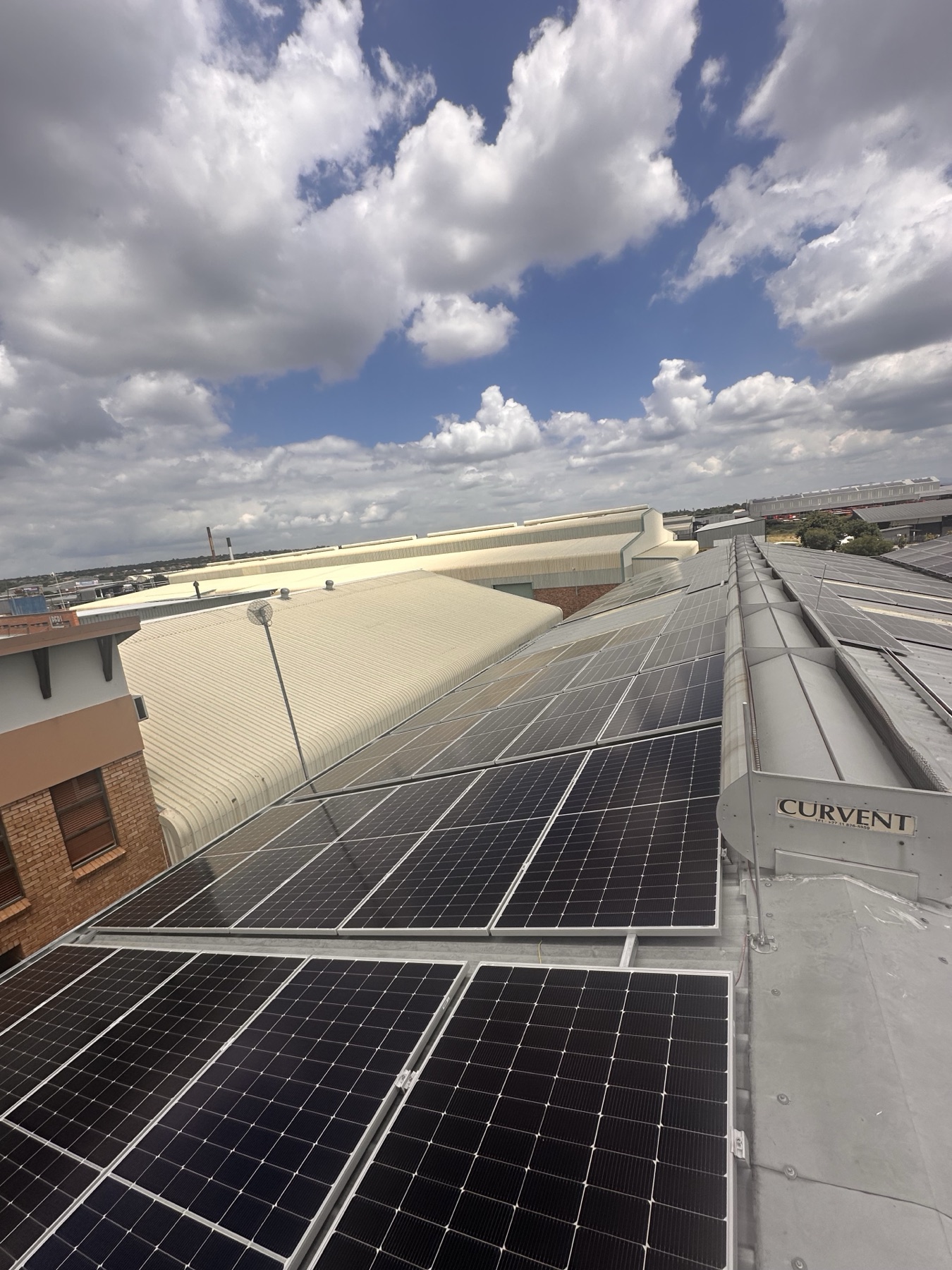 Industrial rooftop solar array beneath a blue sky